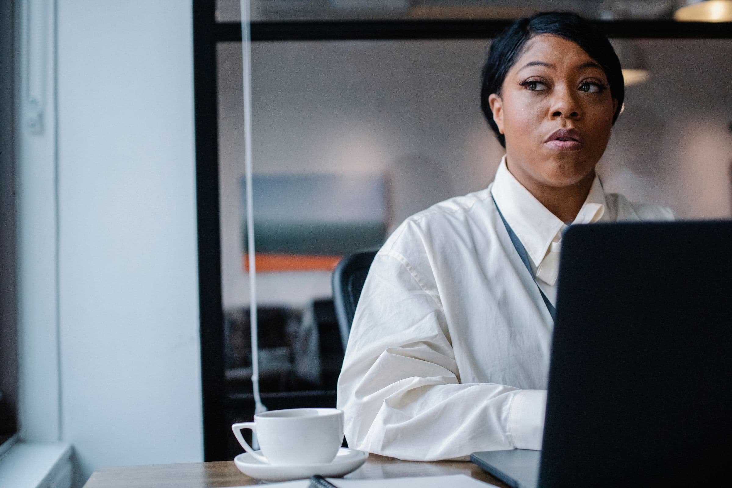 A professional working through her day at a laptop in a bright office