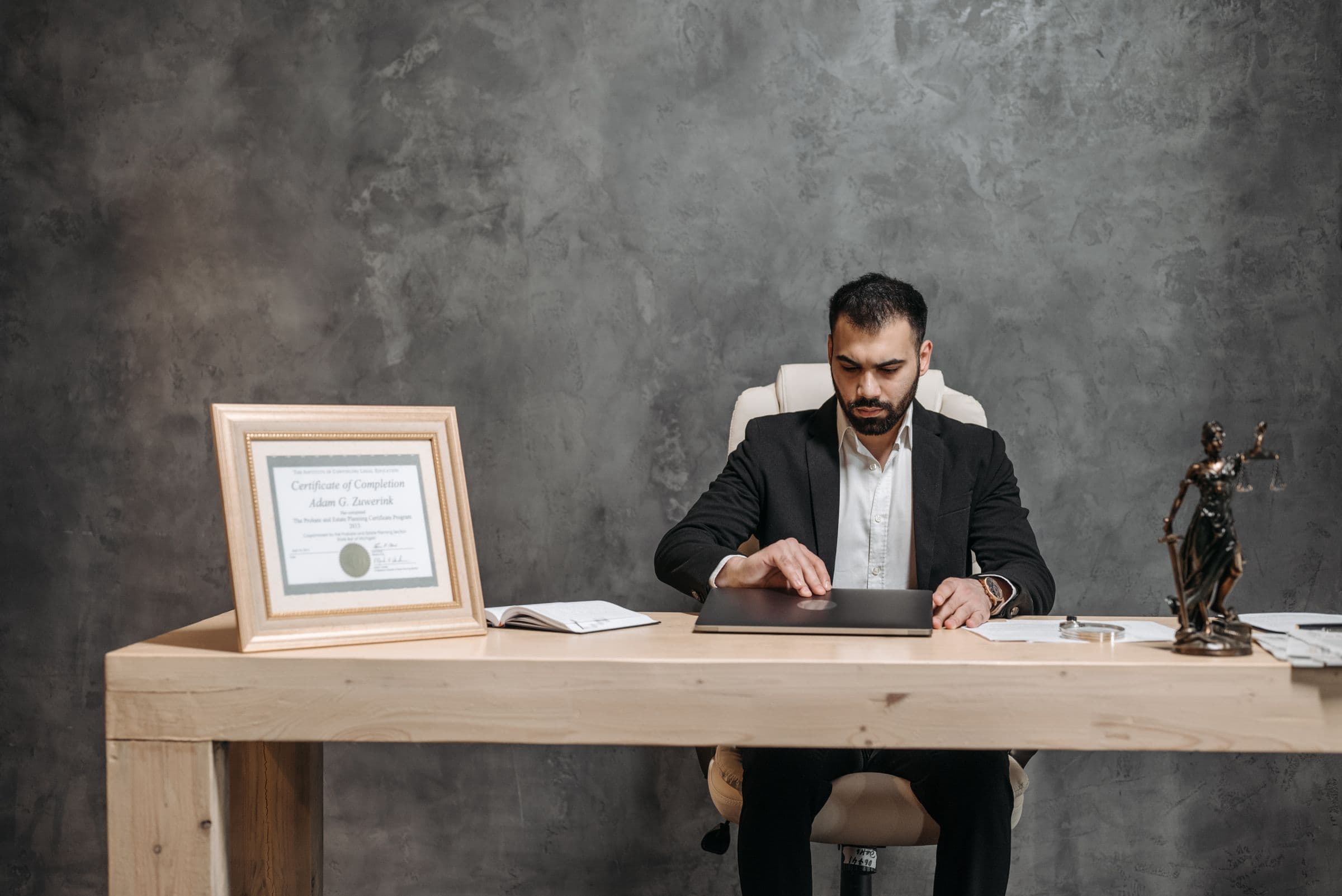 A lawyer working on a laptop at a desk with scales of justice
